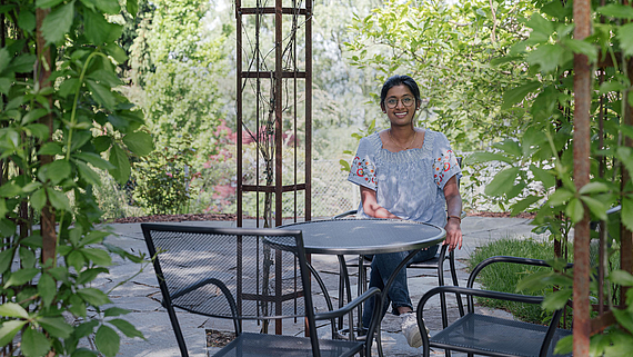 Kavina Maheswaran, diplomierte Pflegefachfrau HF in der Klinik Meissenberg, sitzt an einem Tisch im Garten der Klinik