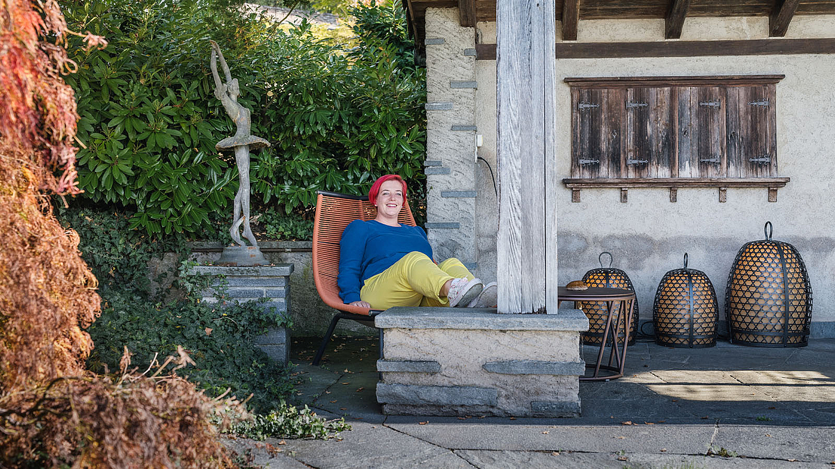 Katrin Lüönd, Köchin in der Klinik Meissenberg, auf einem Sessel im Garten der Klinik.