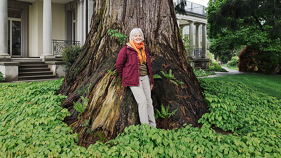 Eliane Zwyer, Peer-Arbeiterin der Klinik Meissenberg, vor einem Baum im Garten der Klinik.