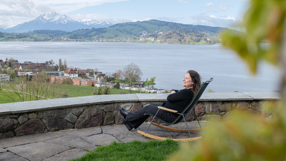 Anja Seidl, Leiterin Prozess- und Qualitätsmanagement bei der Klinik Meissenberg, sitzt auf einem Schaukelstuhl in der Gartenanlage der Klinik und schaut in die Ferne
