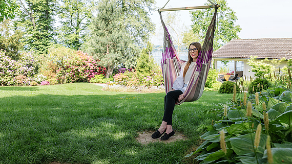 Carmen Savary, Leiterin der Personalabteilung der Klinik Meissenberg, sitzt auf einer Hängematte im Garten der Klinik.
